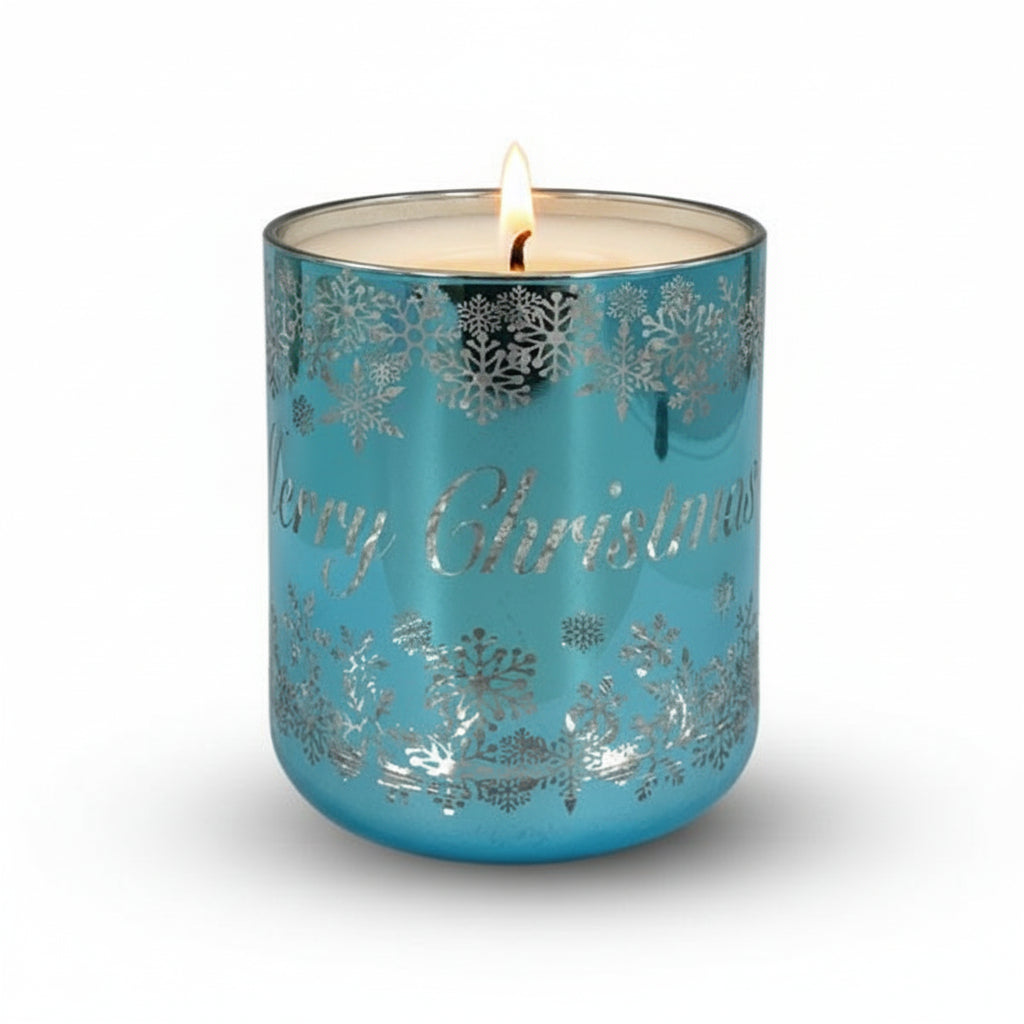A blue and silver colored candle with Christmas-themed decorations on it, placed against a white background.
