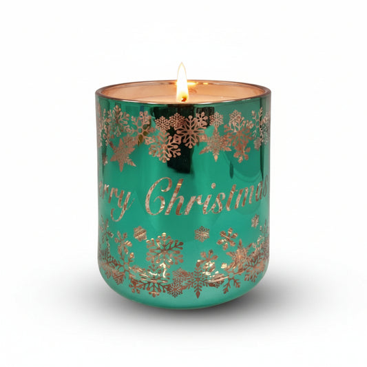 A green glass candle with rose gold accents and 'Merry Christmas' text, decorated with snowflake patterns.