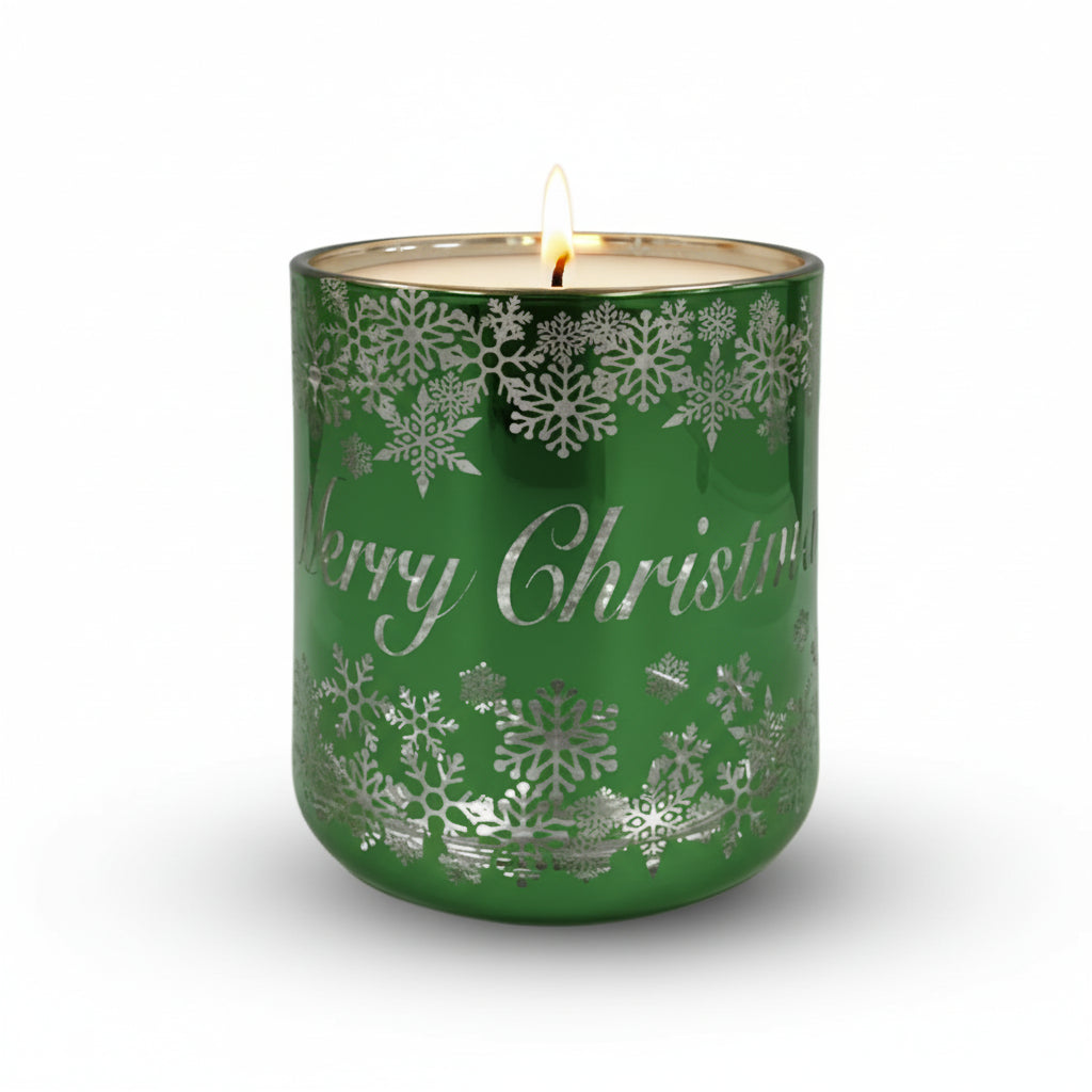 A green glass candle with silver accents and Christmas-themed decoration, including snowflakes and stars, on a white background.