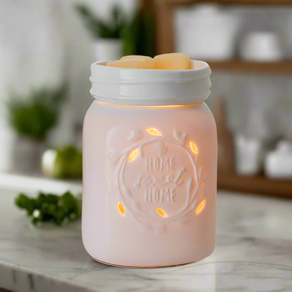 Ceramic mason jar-shaped candle warmer with 'Home Sweet Home' engraving on a marble surface.